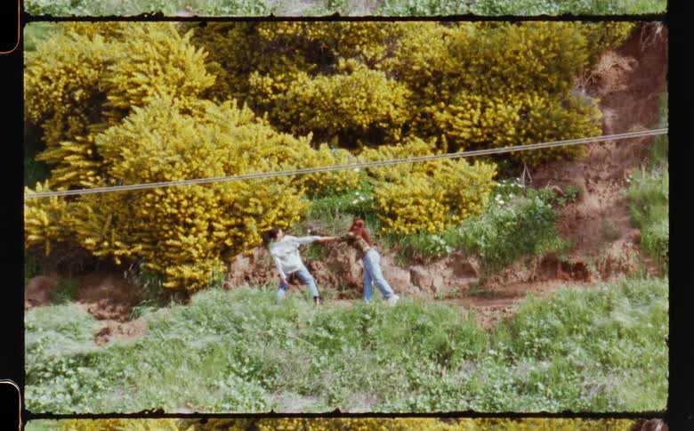 Two women dance on path on slope
