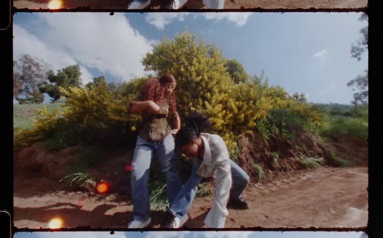 Young couple standing on a dirt road in the countryside dancing caught on vintage film