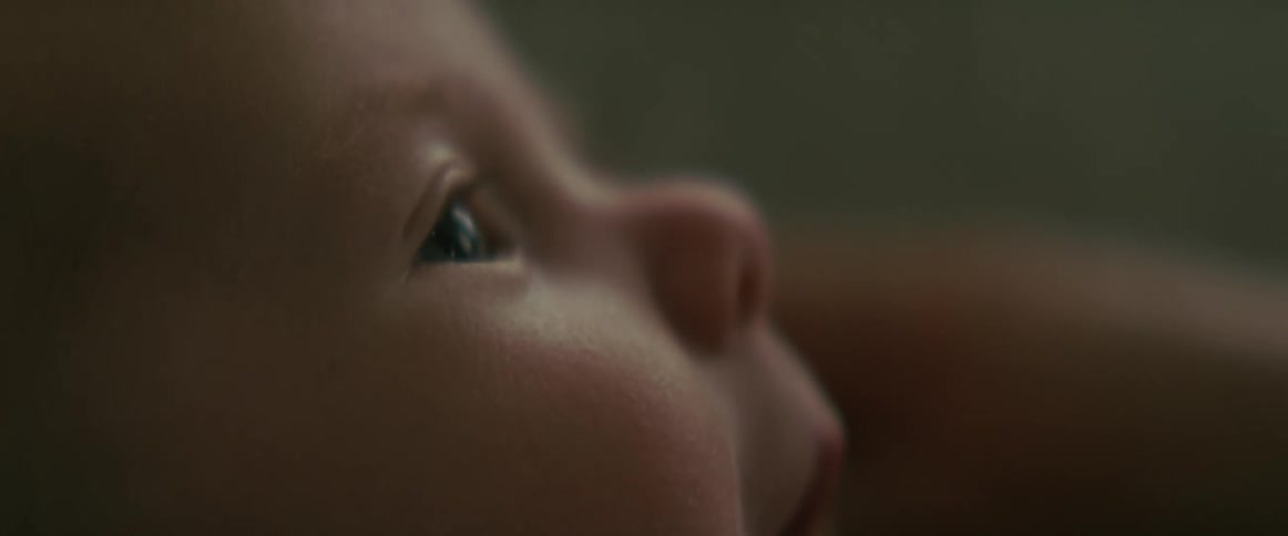 Close up view of a babys face as they look up