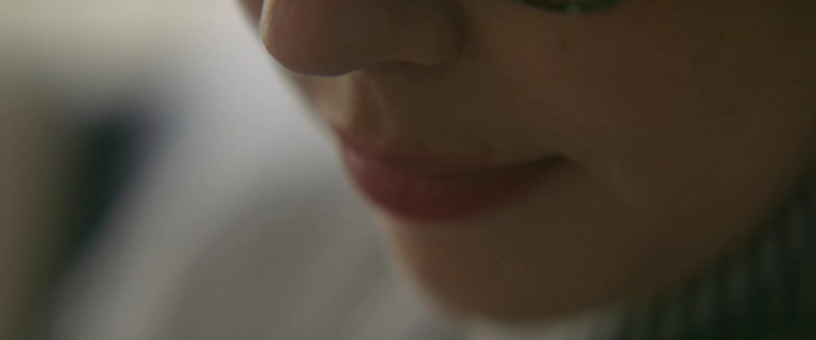 An extreme close up of a womans face lips and nose and glass frame