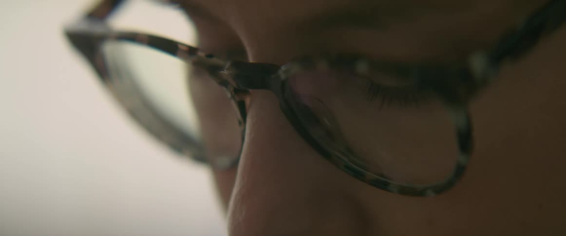 Close up of womans face with glasses looking down