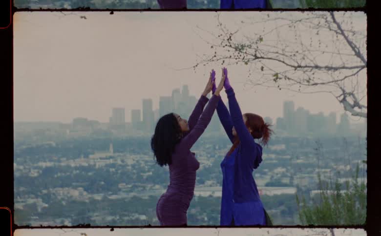 Young couple standing in front of a city dance together caught on vintage film