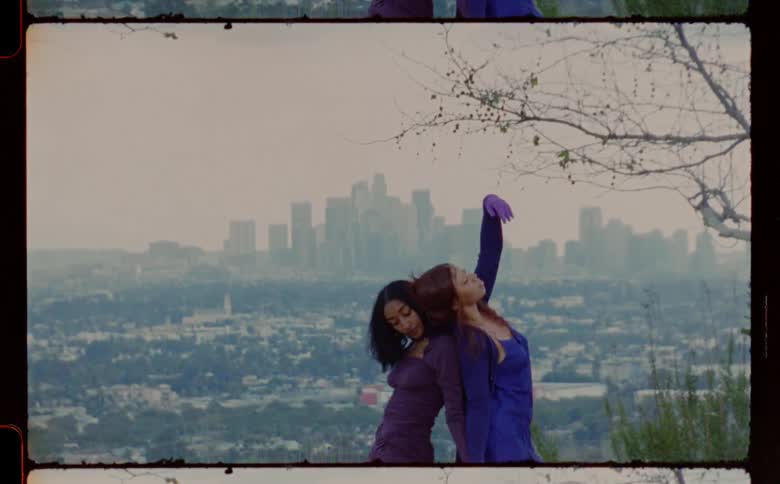 Two women are dancing together outdoors in spring