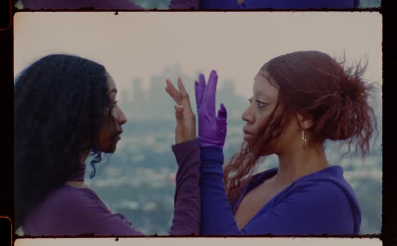 Two women hold their hands against each other between them before turning and walking away