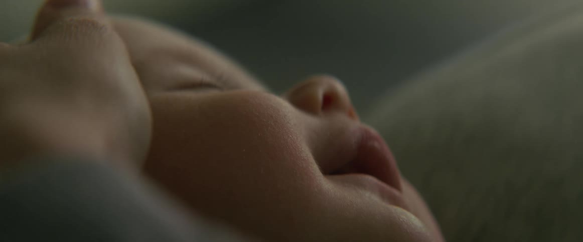 Mother caresses head of sleeping baby