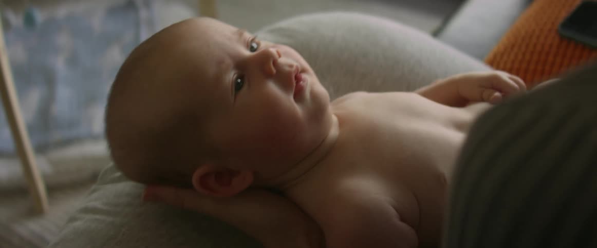 A woman rocks her baby back and forth in her lap