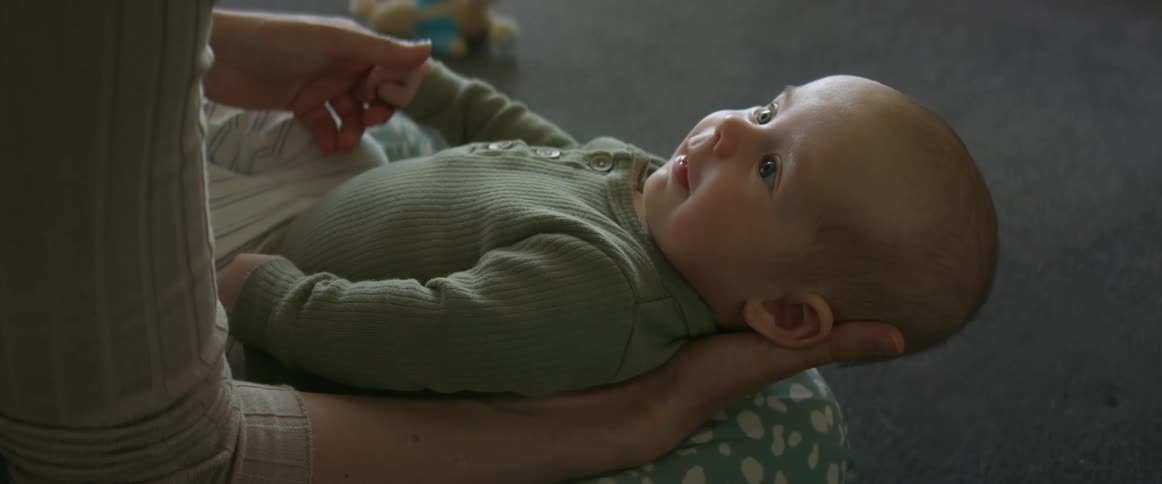 Mother holding baby looking into his eyes and smiling at each other