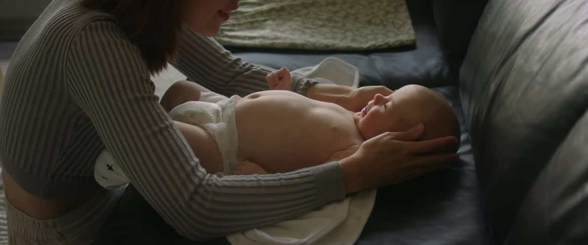 Mother and baby engaging with each other mother touches babys face and baby giggles