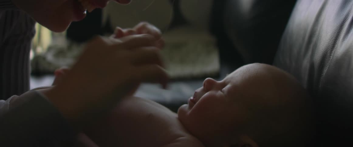 Mother playing with baby on the couch indoors
