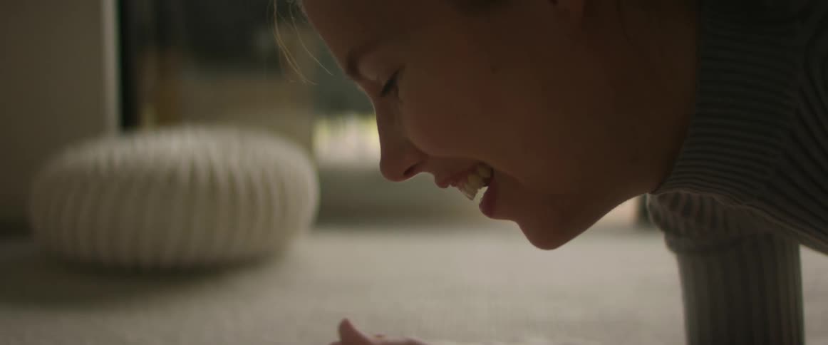 A mother laughs and talks to her baby