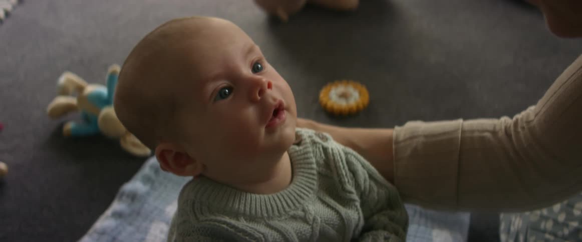 Mother gently kisses her newborn son at home