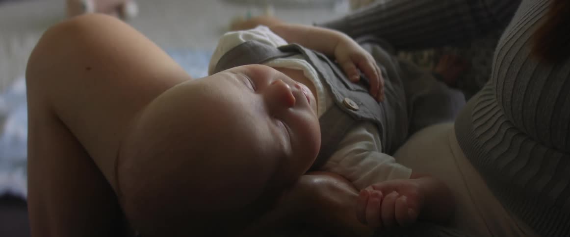 Mother holds sleeping baby in her lap