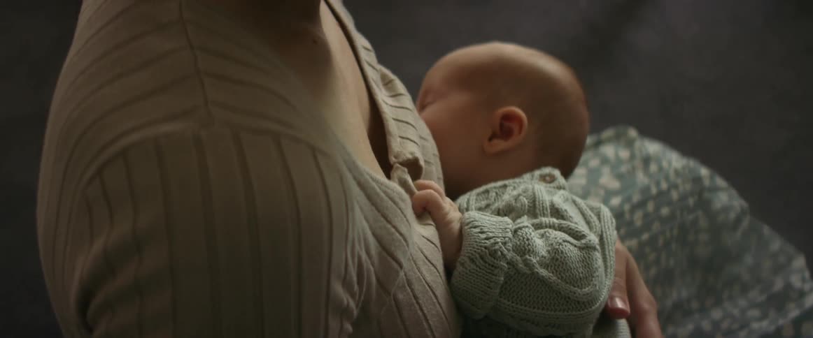Mother holds sweater clad baby close to her chest