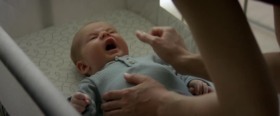 A mother touches her son on the nose in bed