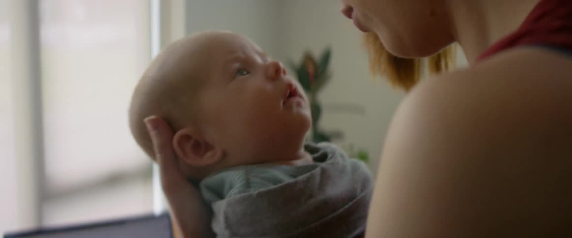 A mother is rocking her newborn son