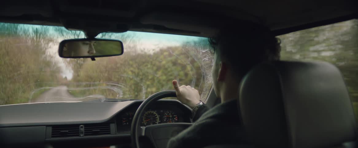Man drives car on country road