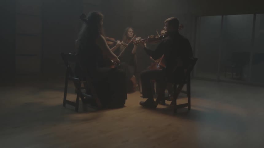 A group of people playing instruments in a dim room