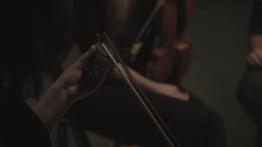 A person polishes the stick for their musical instrument