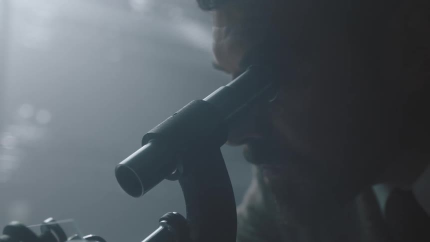 A man looks into a microscope