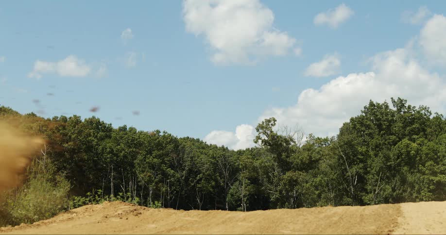 Motorcyclist jumps on motocross course near woods