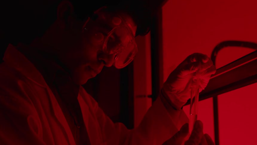 A man is examining a test tube