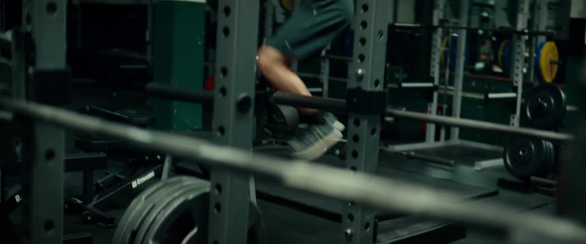 Man jumps up and down on stand in gym near the weights