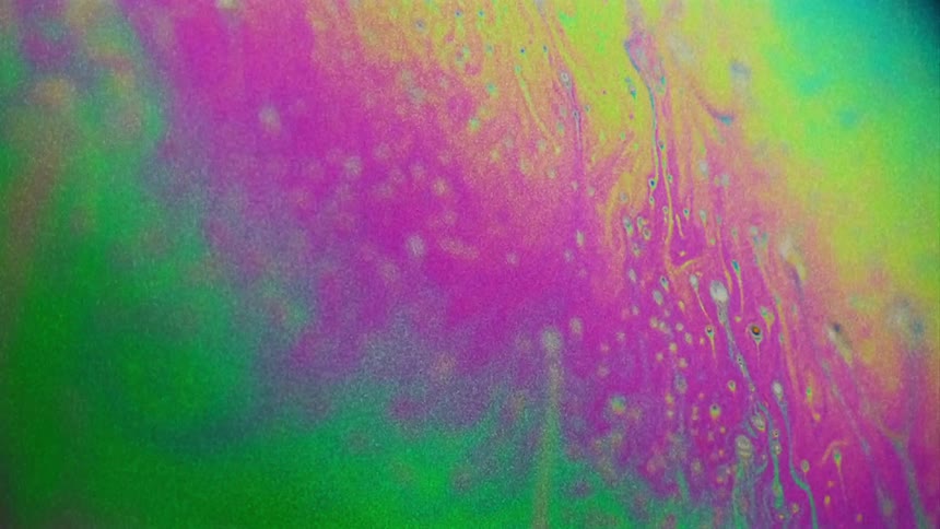 Abstract colorful liquids moving against glass with some bubbles