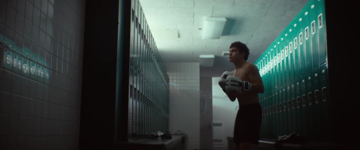 A man is shadowboxing in the locker room