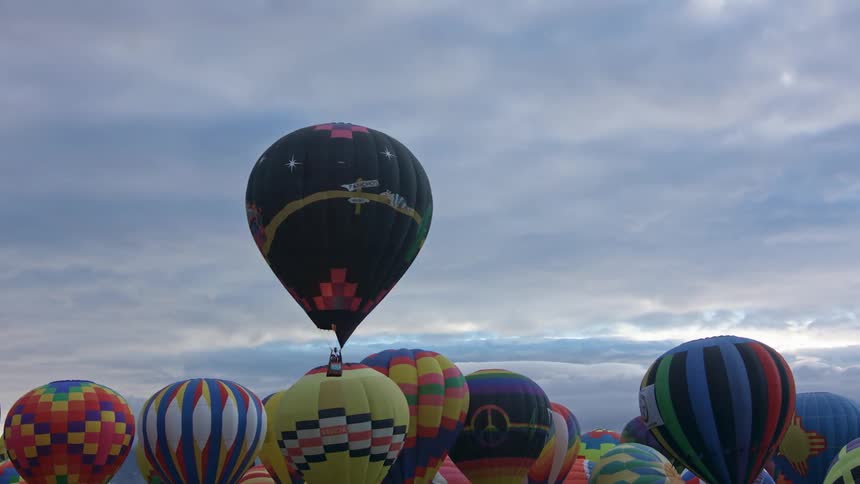 A group of hot air balloons are floating