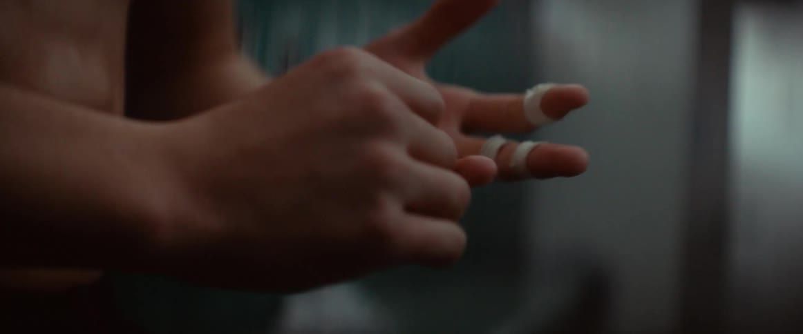 A close up of a mans hands and fingers as being wrapped in tape