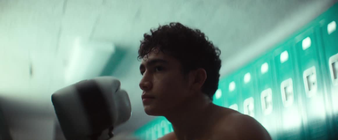 Male boxer shadowboxes in locker room