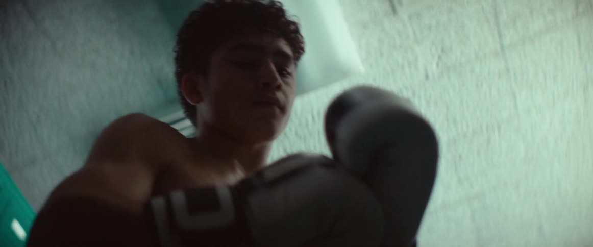 The teenager is wearing boxing gloves