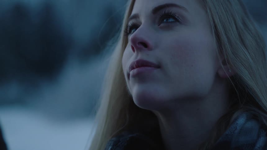 A blond woman looks up at someone else