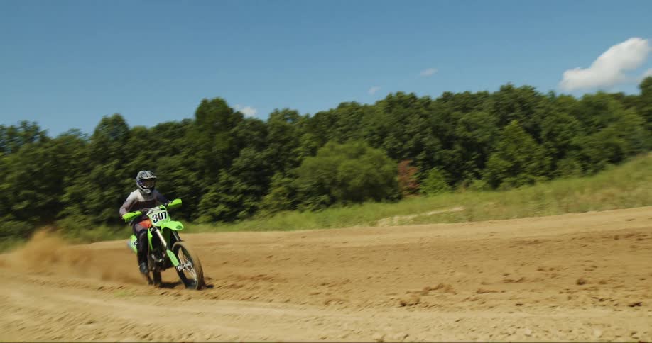 A man jumps over a hill on a dirt bike