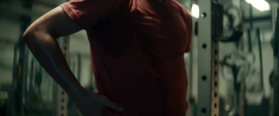 A man stops to take a break while working out at a gym