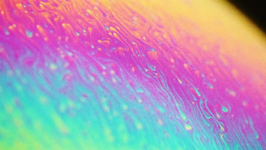Rainbow ink colors and droplets rolling on a sphere