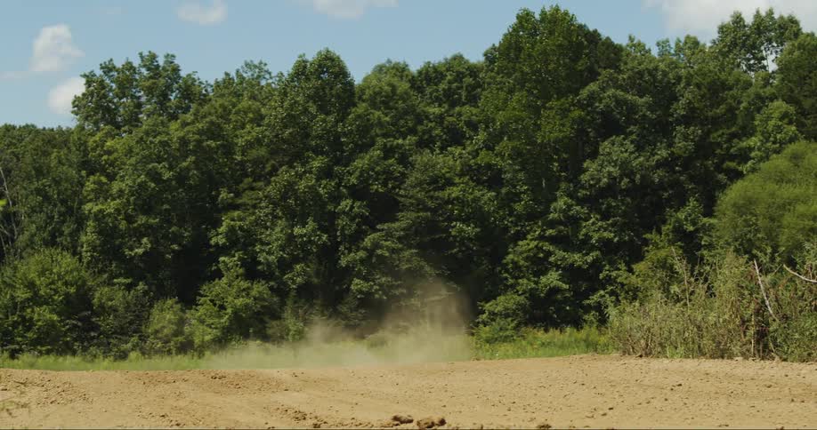 A person riding a dirt bike and jumping it on a dirt track