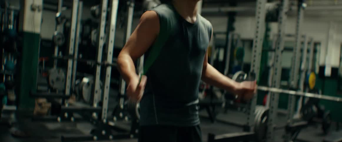 Man works out by jumping rope in gym near weights