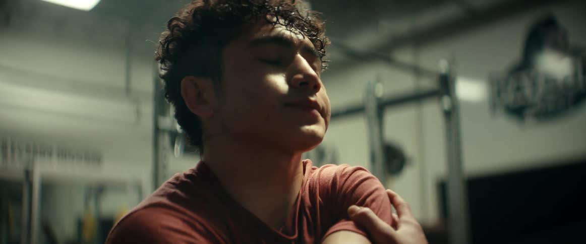 A man stretches his arm out while in the weight room at a gym