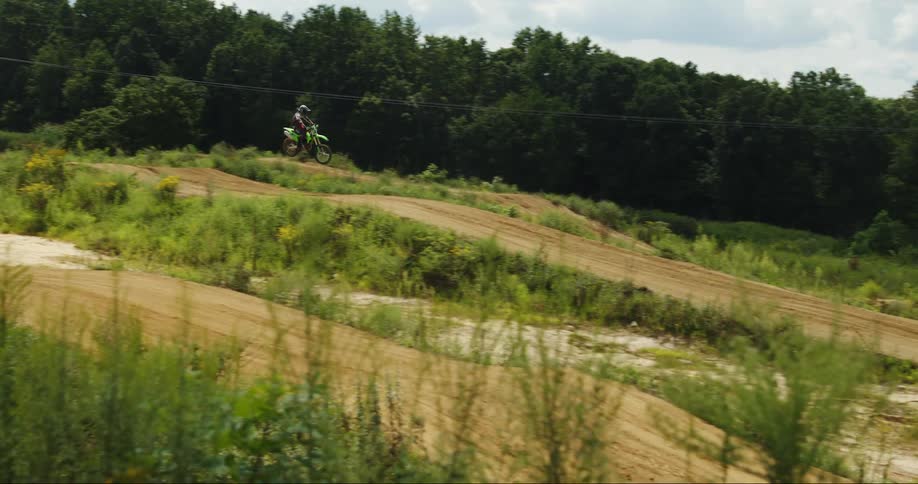 A person does jumps on the dirt bike on hills