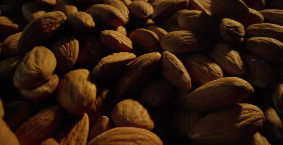 Light shines on fresh almonds piled in a basket