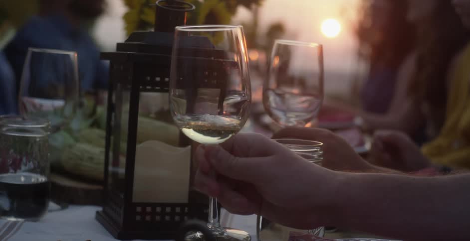 A group of people sitting at a table with glasses and wine being poured
