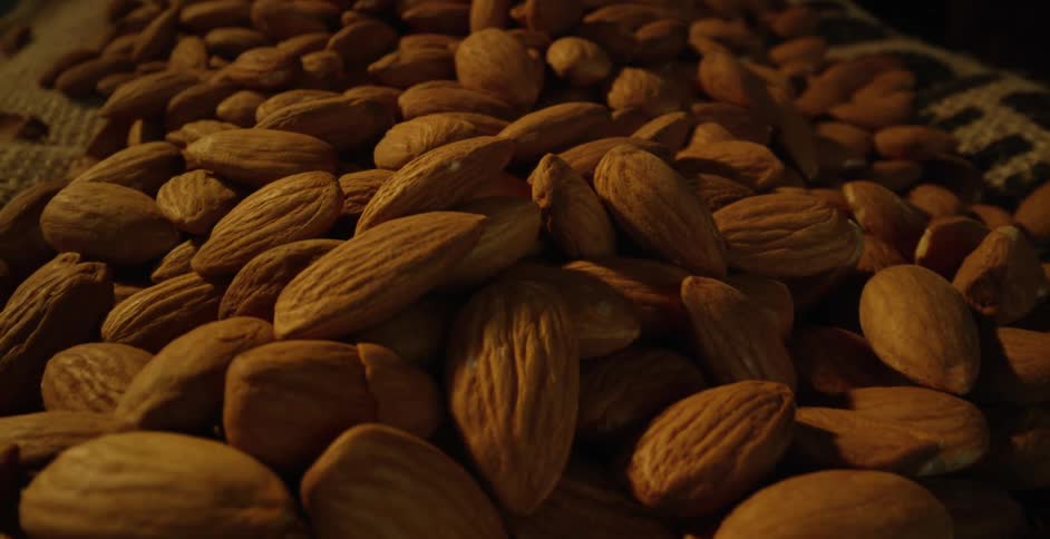 Light shines on fresh almonds piled in a basket