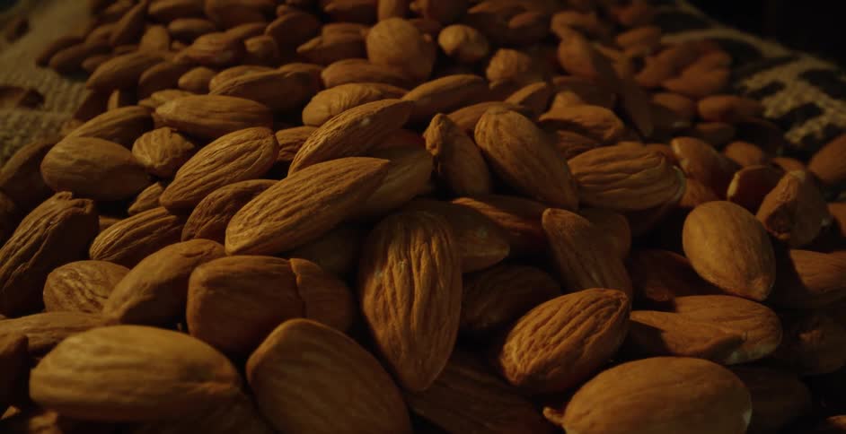 Light shines on fresh almonds piled in a basket