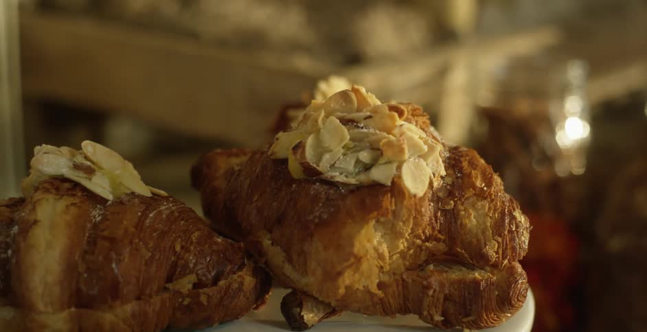 Almond croissants sit on a serving platter at a bakery