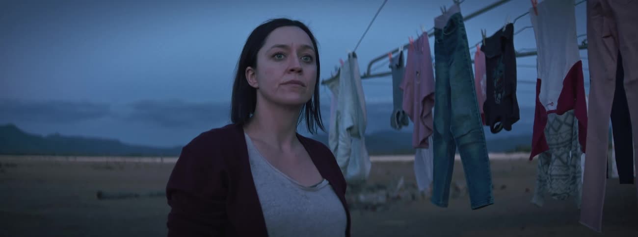 A woman is hanging clothes on the clothesline