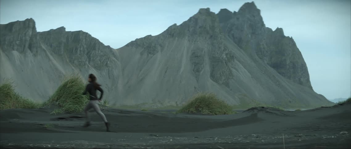 A woman runs past the mountains
