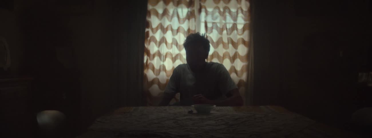 A person is sitting in a very dark room