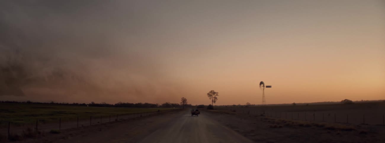 A car is driving on the dirt road