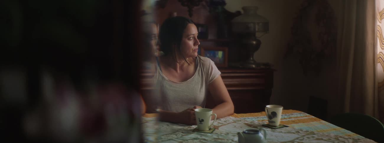 A woman waits for her husband at the kitchen table